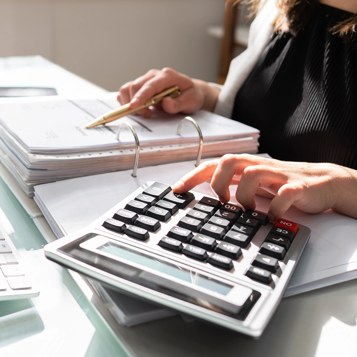 Person using a calculator and taking notes.